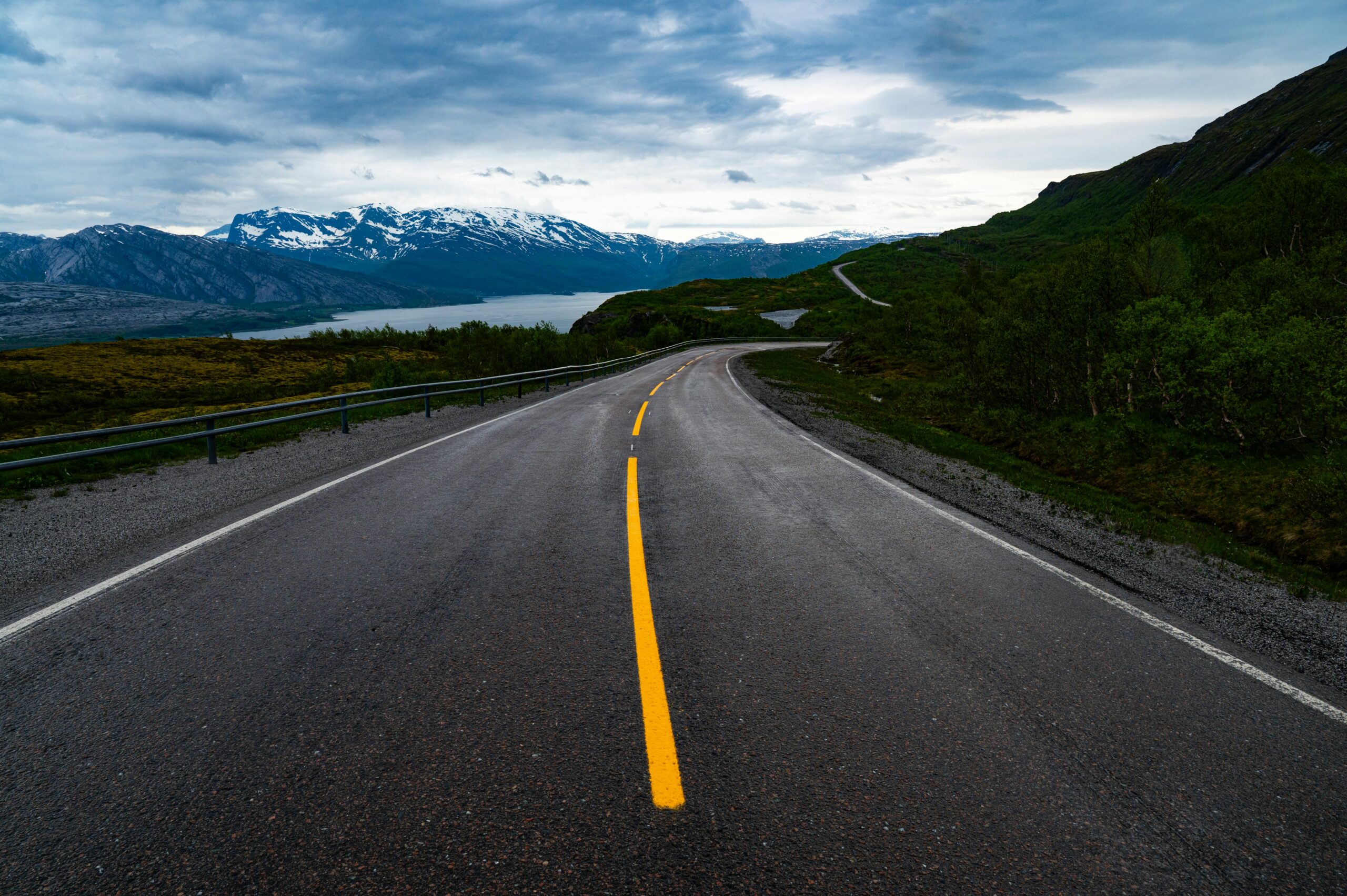 Malerische Bergstraße mit Blick auf einen norwegischen Fjord – ein Symbol für die ungeschriebenen Regeln, die Reisende in Norwegen kennen sollten.