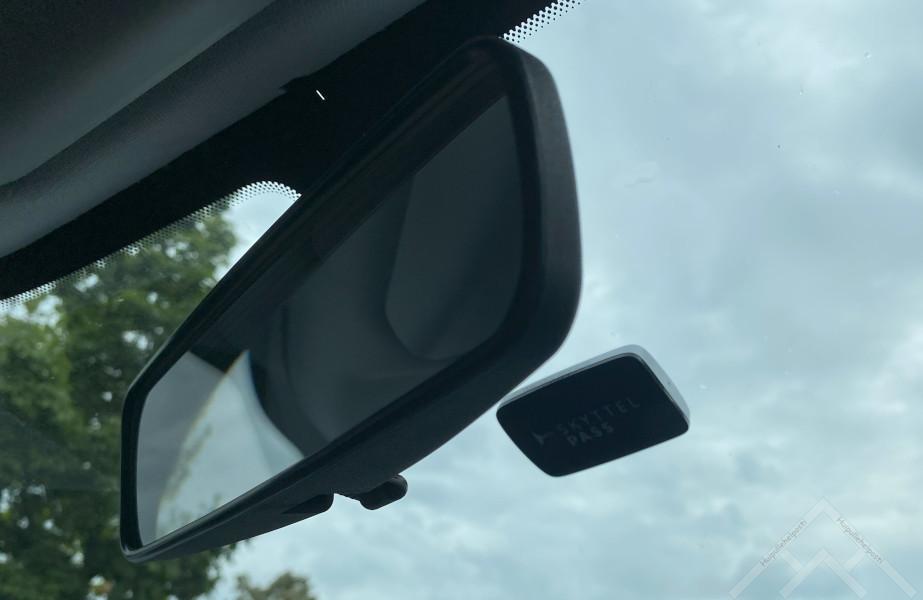 An AutoPASS electronic toll tag mounted on a car windshield for automatic toll roads in Norway